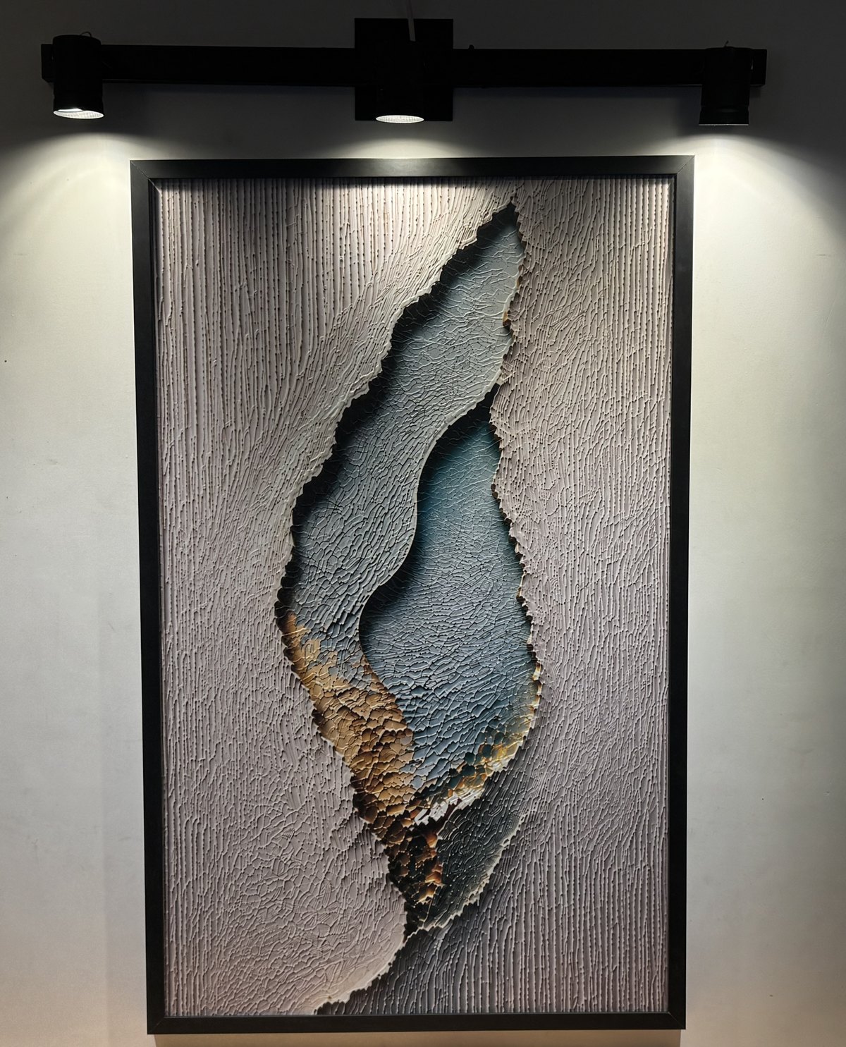 Esencia Interior, obra en relieve de la Colección Origen, colgada con luz de riel