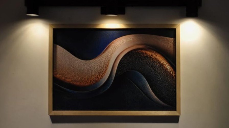 Flujo Eterno, obra en relieve colgada e iluminada
